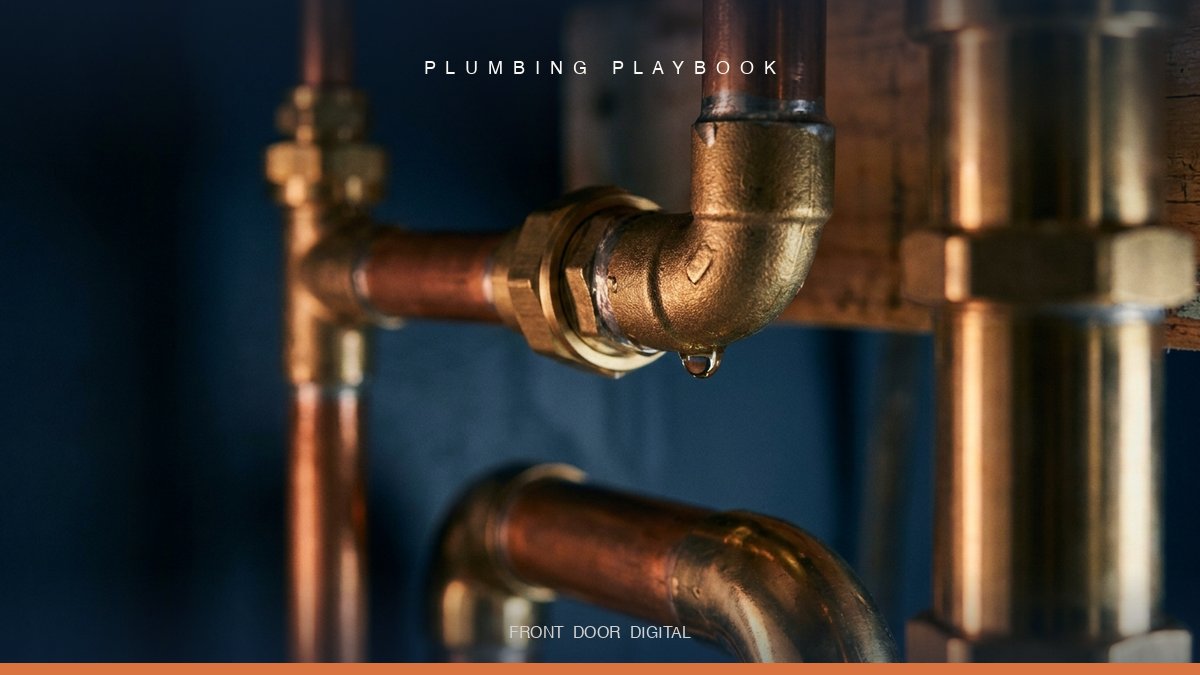 Macro close-up of polished brass and copper pipe fittings under a sink with dramatic moody lighting